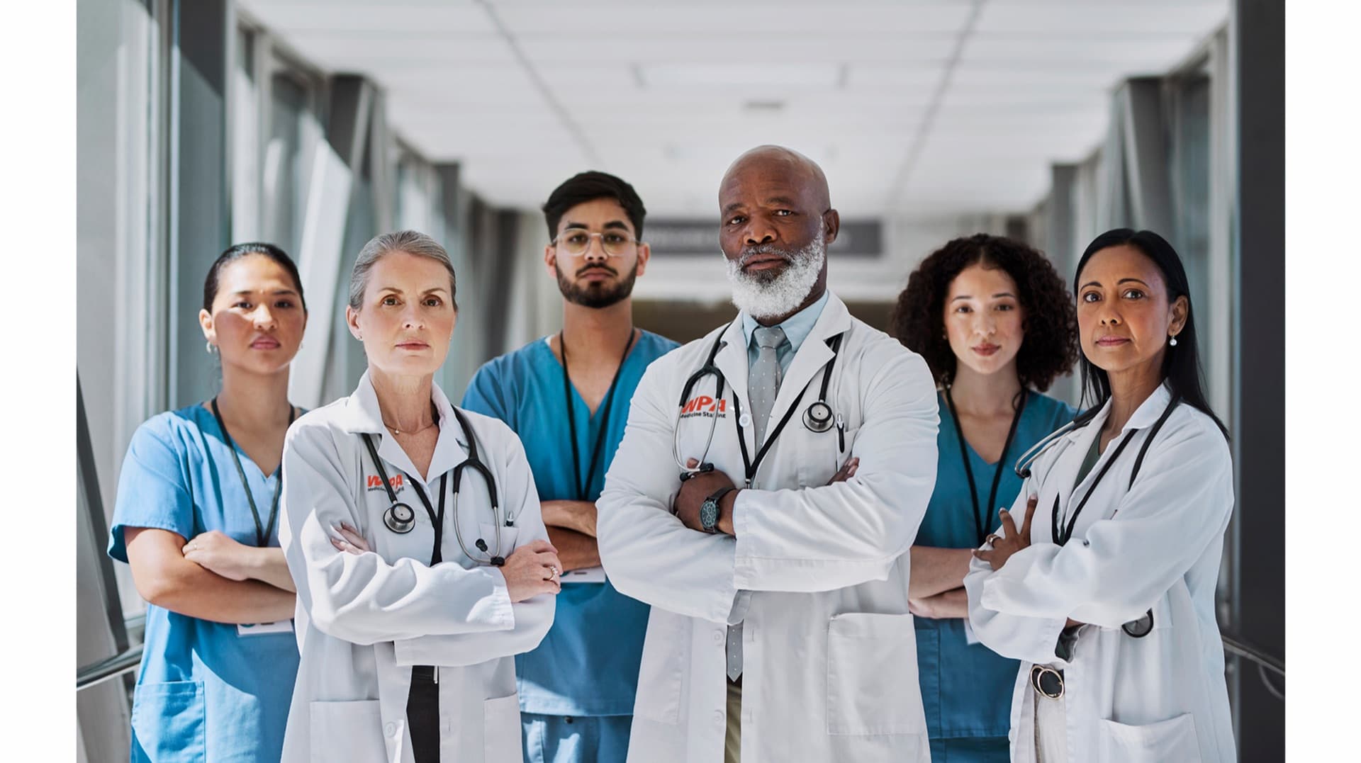 A team of physicians and clinicians standing together in a hospital corridor